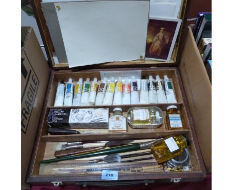 An artist's box of oil paints and other materials, together with a sketch pad 
