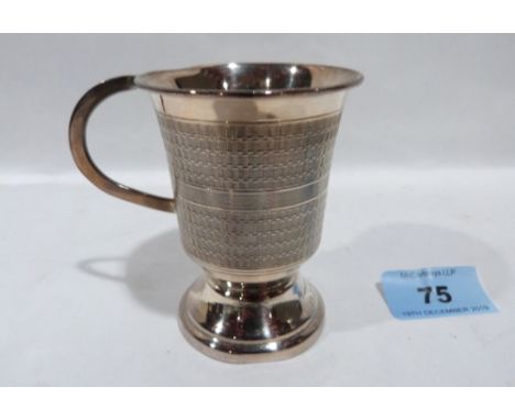 A silver engine turned christening mug. 3' high. Marked Sterling Silver. 3ozs 6dwts