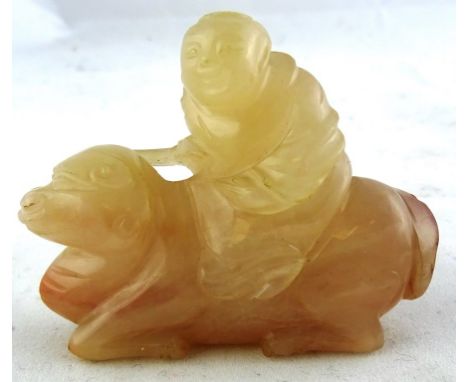 A Chinese jade carving

19th/20th century

Of a light brown tone with darker streaks. in the shape of a figure sitting on a c