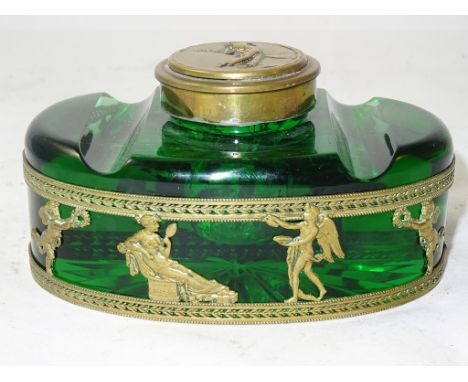 A 20th century green glass inkwell of oval form with a frieze of winged putti and classical figures, the lid with golfer