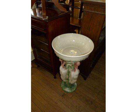A modern ceramic planter on stand decorated with storks