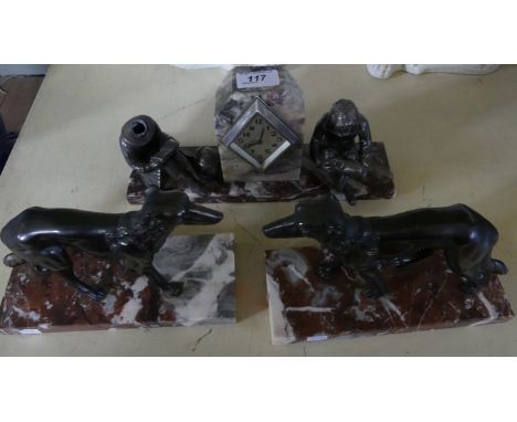 An Art Deco period marble mantel clock decorated with two cast metal models of children, together with a further pair of spel