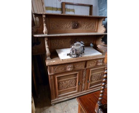 A large 19th Century carved oak sideboard with two drawers above two panelled doors and carved back with shelf.