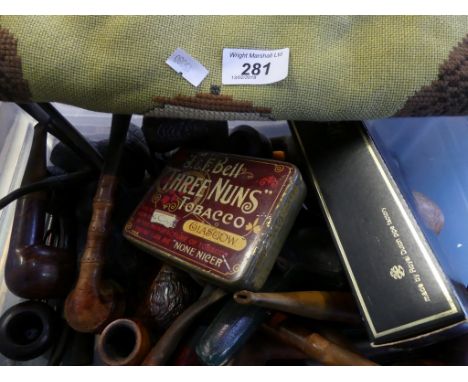 A large collection of various tobacco pipes and a tapestry pipe display.