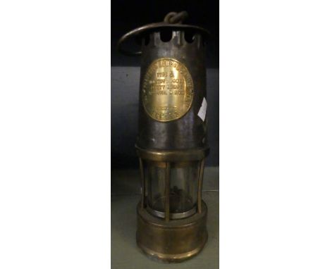 A vintage miners lamp marked 'The Protector Lamp and Lighting Co, Eccles.