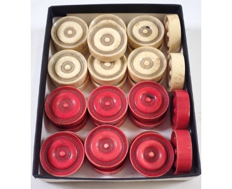 An antique set of bone draughts pieces 15 white and 14 red&nbsp;