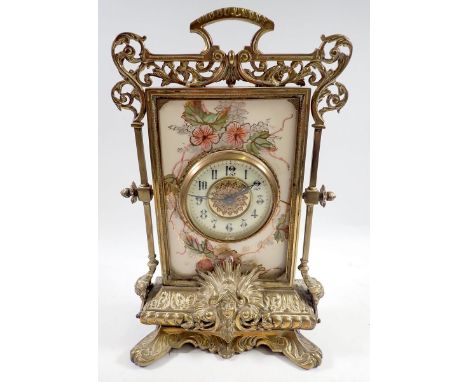 A 19th century French ornate brass mantel clock in the form of a table screen inset with a porcelain floral painted panel, 35