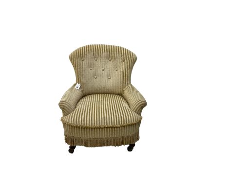 Late 19th century low seat armchair, upholstered in button back striped fabric with sprung seat, on front turned supports wit