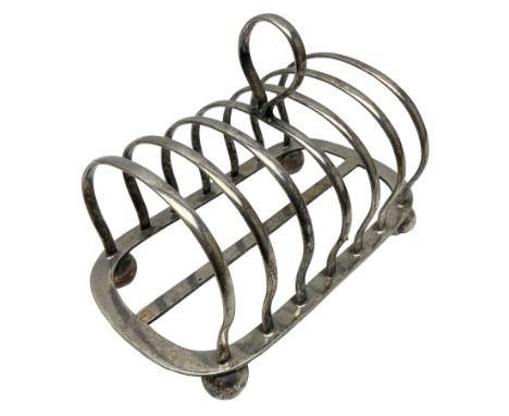Silver plate seven bar toast rack, of curved form with central ring handle, upon bun feet, H13cm 
