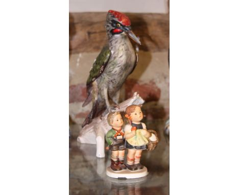 A Goebel ceramic model of a green woodpecker, 11" high, and a Hummel figure of two children