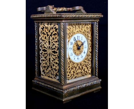 A French late 19th Century carriage clock in ornate brass case with rope twist edges, face and sides decorated scroll pierced
