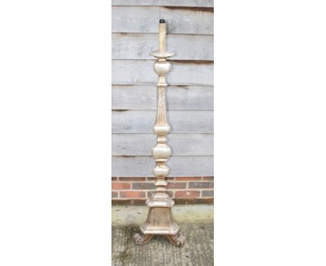 A standard lamp formed as a pricket candlestick, on triform base and scroll feet