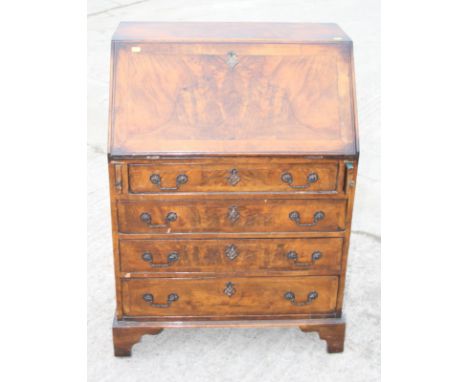 A figured walnut fall front bureau with fitted interior over four long graduated drawers, on bracket supports, 28" wide