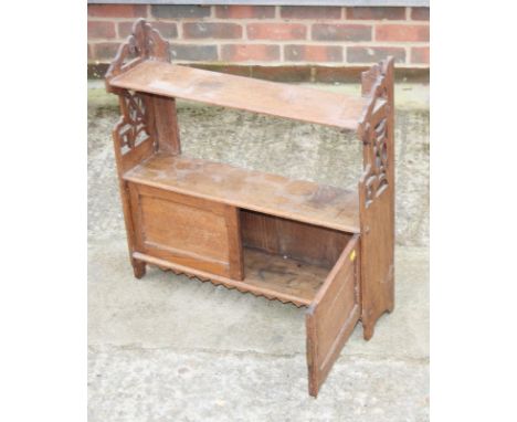 A late 19th Century oak wall hanging shelf with pierced panel sides fitted cupboards, 24" wide