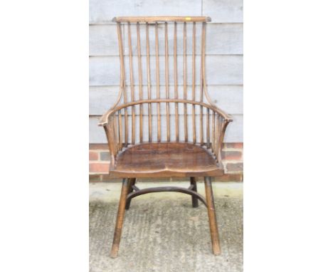 A 19th Century ash and elm comb back elbow chair with panel seat, on turned and stretchered splay supports