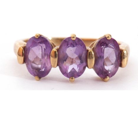 Modern 9ct gold amethyst ring, a design with three oval cushion cut amethysts, individually claw set in a pierced gallery, si