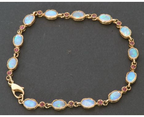 Modern 9ct gold opal and small ruby bracelet featuring 13 oval shaped opals in cut downs settings, interspersed with small be