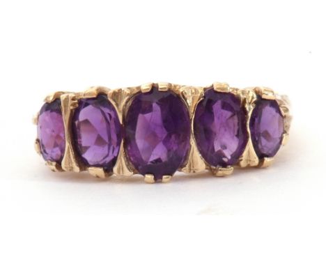 9ct gold amethyst five stone ring, featuring five graduated oval shaped amethysts, all in a carved gallery, size L/M