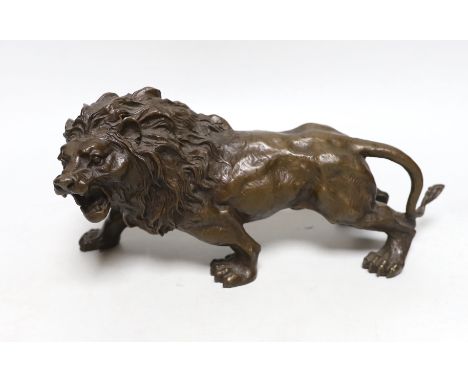 A hollow cast bronze model of a lion, 33cm long
