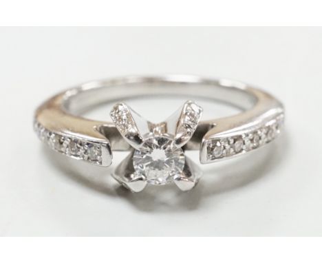 A modern 18ct white gold and claw set single stone diamond ring, with diamond chip set shoulders, size M, gross weight 5.2 gr
