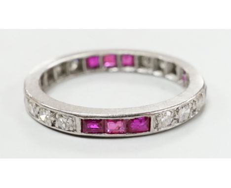 A white metal, ruby and diamond set full eternity ring, size L/M, gross weight 3.1 grams.