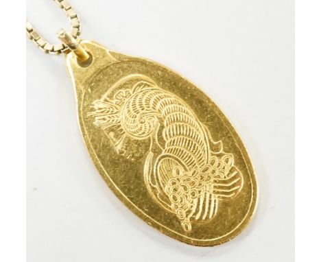 A Suisse 10g yellow metal 'Fine Gold 999.9' oval ingot pendant, on a 9ct gold chain, 3.6 grams.