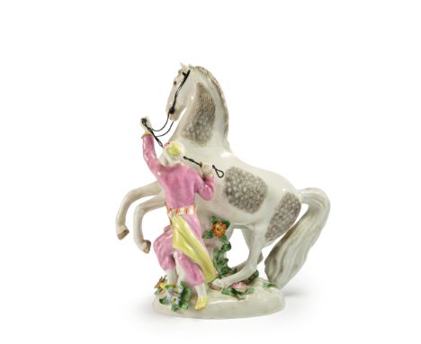 A porcelain figure of a horse and its Turk groom,  Samson, France, late 19/early 20th century, prancing in a meadow, its brid