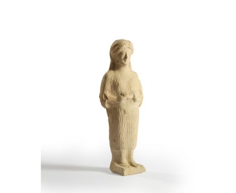 A Greek terracotta figure of a woman Sicily, circa 5th Century B.C.The hollow figure standing holding a pig, her face with ar