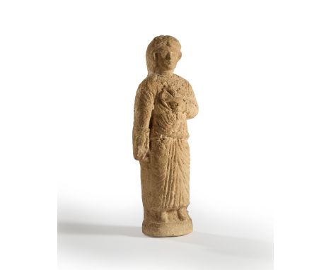 A carved limestone figure of a woman holding a bird,  Probably Roman, Cyprus, 2nd-4th century A.D.37.3cm highProvenance: Priv