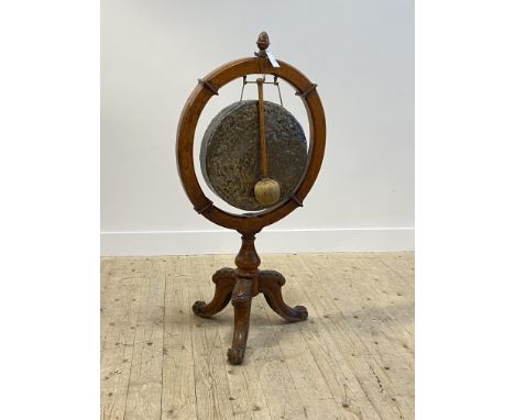 A Victorian oak framed dinner gong, with urn finial over hammered brass gong, raised on scrolled triple splay supports, compl