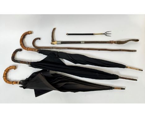 Two bamboo handled vintage gilt metal mounted umbrellas, (L: 91cm and 83cm) a silver mounted cow horn handled umbrella with s