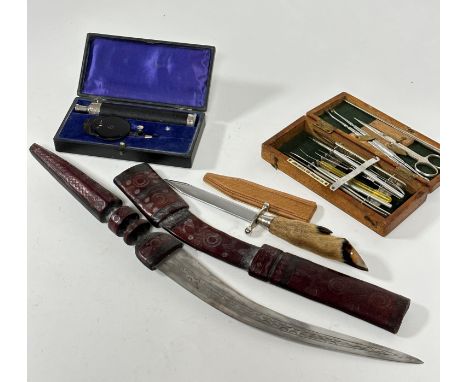 A North African leather covered curved short sword with leather tooled scabbard, with engraved blade, (L: 56cm including scab