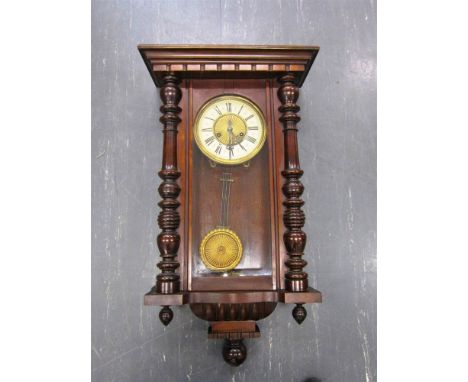A DROP DIAL WALL CLOCK the enamel dial with Roman numerals, and contained within a carved turned case, 76cm high