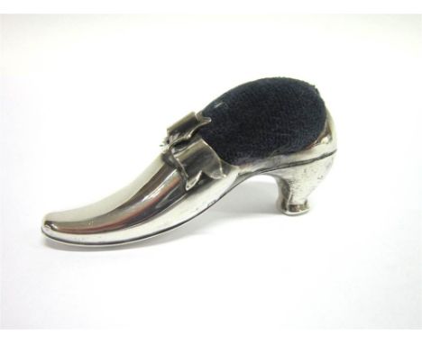 A SILVER SHOE PIN CUSHION  by Adie & Lovekin Ltd, Birmingham 1905, the shoe with a bow applied, 6.3cm long