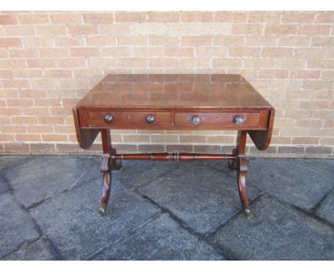 A VICTORIAN MAHOGANY SOFA TABLE fitted with two short drawers, the four outswept supports joined by stretcher rails and with 