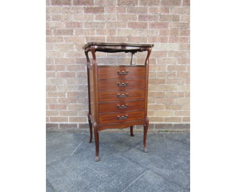 AN EDWARDIAN INLAID MAHOGANY MUSIC CABINET with shaped rectangular shelf and with five serpentine fall fronted drawers under,