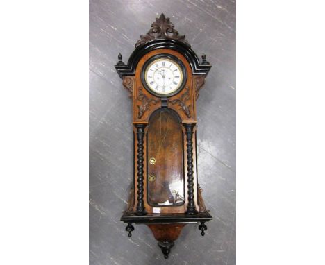A VIENNA REGULATOR WALL CLOCK the enamel dial with Roman numerals and contained in an ornate carved walnut case, 116cm high