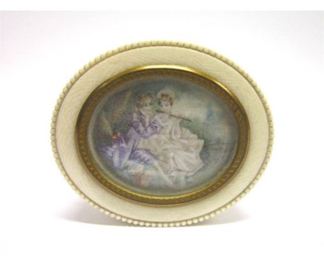 A LATE 19TH CENTURY OVAL IVORY MINIATURE SET BOX the pull off cover with a miniature of a seated couple, she playing a flute,