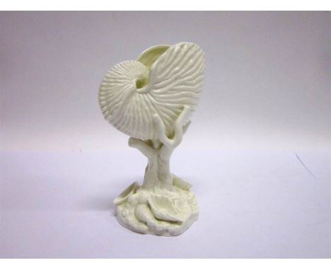 A ROYAL WORCESTER PORCELAIN VASE in the form of a nautilus shell on a  tree stump, supported by branches with various shells 