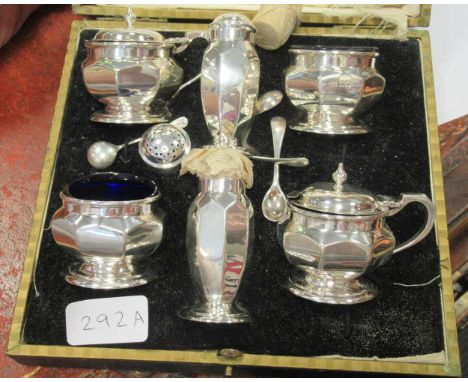 A silver six piece condiment set of octaganal form comprising two lidded mustards with blue glass liners and spoons, two salt