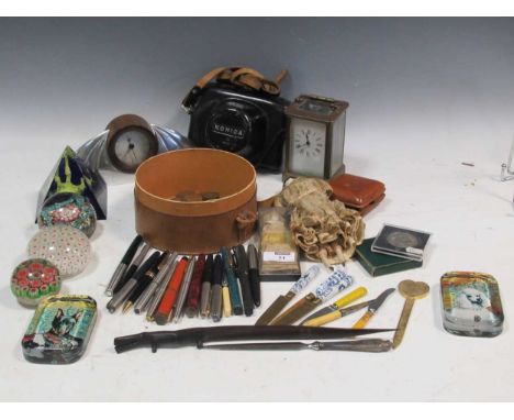 A collection of items to include paperweights, pens, a small Art-Deco style mantle clock etc.