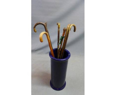 An early 20th century blue glazed stoneware stick stand, together with seven walking sticks 