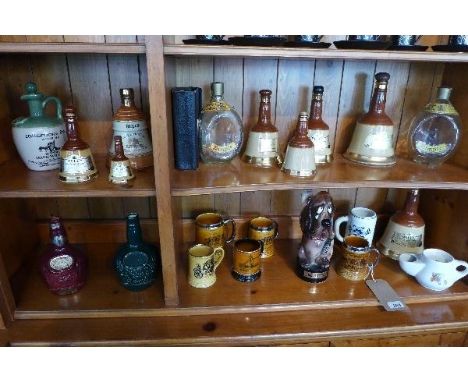 A collection of nine Wade ceramic whiskey bottles, plus others, together with a musical decanter in the form of a dog and cer