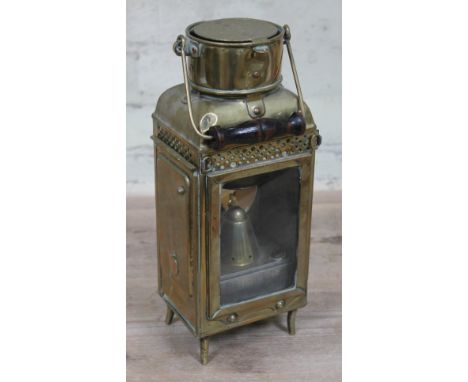 A brass lantern with wooden swing handle, glazed front, sliding side revealing burning stamped 'E.C&amp;S 1919' and convex br