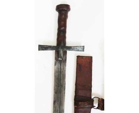 A Sudanese kaskara sword, blade length 80cm, cross guard, leather bound handle and leather scabbard, total length 94cm.  