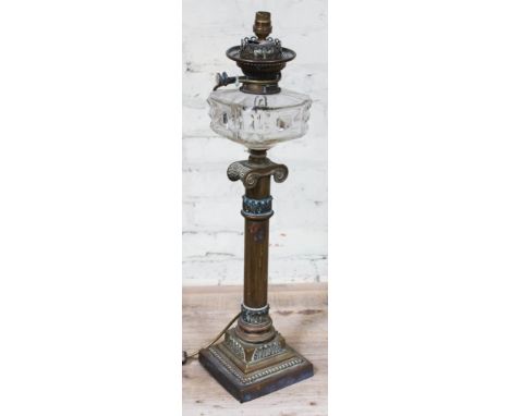 A Victorian brass lamp with cut glass reservoir, single column with acanthus mouldings and ionic capital, stepped base, conve