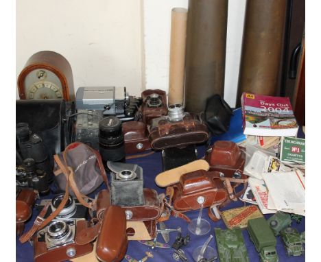 A mantle clock together with a collection of 35mm cameras, binoculars, shell cases, cigarette cards etc