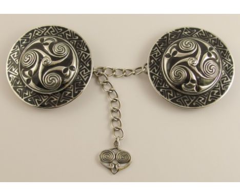 A rare Alexander Ritchie cloak fastener white metal of twin shield shape, each with four spiral bosses and stylized leaf moti