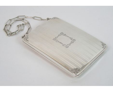 A sterling silver card/sovereign case of rectangular form with engine turned decoration, floral engraving in each corner and 