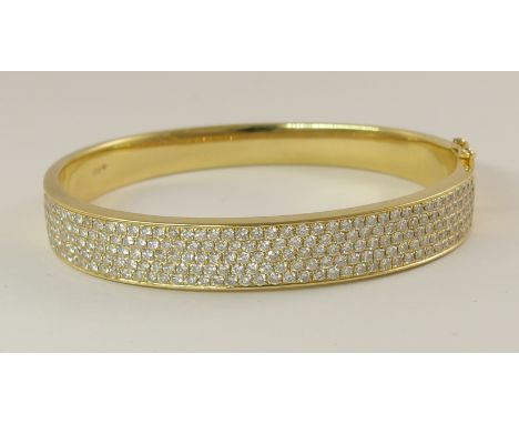 An 18ct yellow gold diamond set bangle the front portion pave set with estimated approximately 2.50cts of brilliant cut diamo